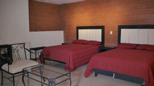 a hotel room with two beds and a chair at Hotel Dubai de Miramar in San Blas