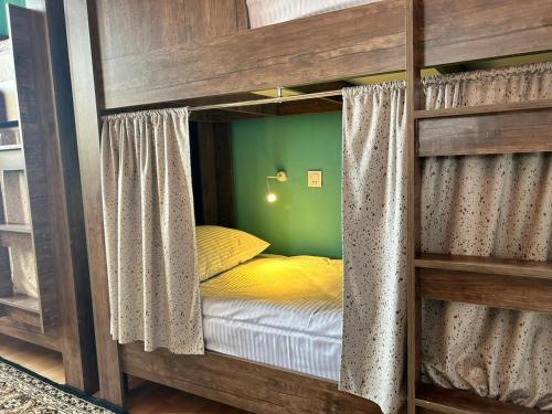 a wooden bunk bed in a room with a yellow bed at HOSTEL124 in Baku