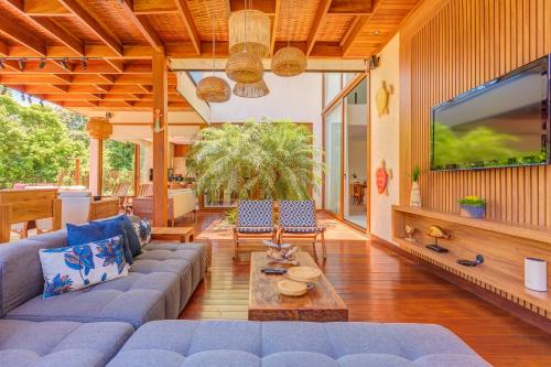 a living room with a blue couch and a tv at Casa Ofir - Alto Padrão in Praia do Forte