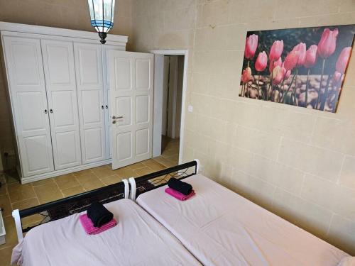 a bedroom with a bed with pink pillows on it at Unique Farmhouse in the Heart of Gozo - Nadur in Nadur