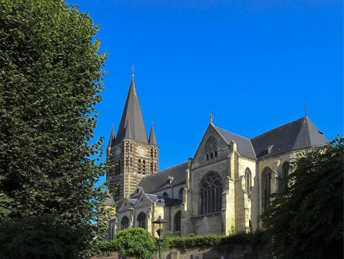 a church with a clock tower on a blue sky at Het Molenaarshuis in Thorn