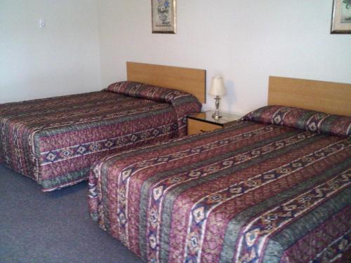 a hotel room with two beds in a room at Caravan INN in Quesnel