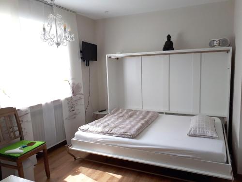 a bedroom with a white bed with a shelf at Grünkraut Salzgeber in Ravensburg