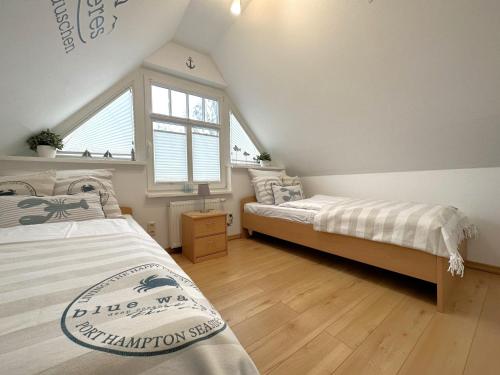 2 Betten in einem Zimmer mit Fenster in der Unterkunft Müggenburger Weg  " Meeresrauschen 2 " in Zingst