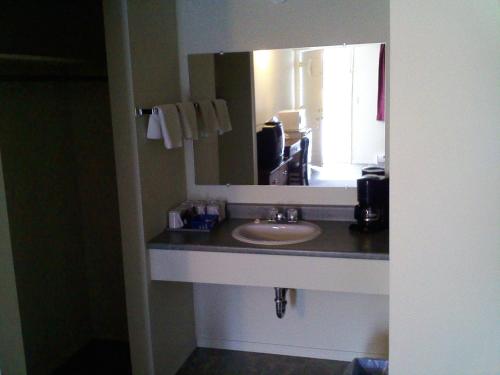 uma casa de banho com um lavatório e um espelho em Caravan INN em Quesnel