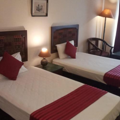 a hotel room with two beds with red and white at THE WYTE FORT in Cochin