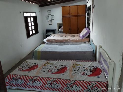 two twin beds in a room with two bedsitures at Aconchego do bens in Cruz