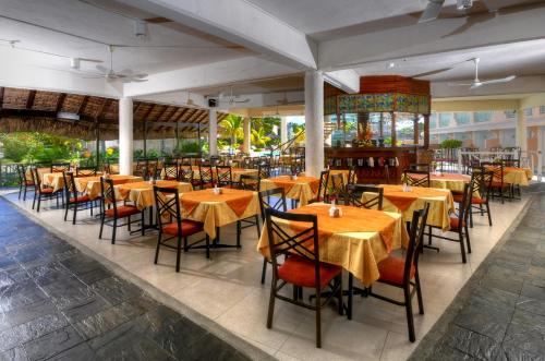 a dining room with tables and chairs in a restaurant at Casa Florida Hotel & Spa in Pereybere