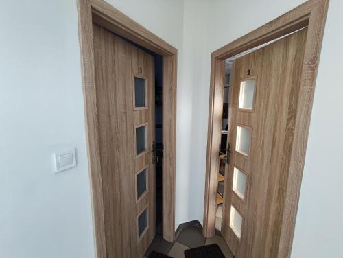 a pair of wooden doors in a room at Váralja Vendégház Tata in Tata