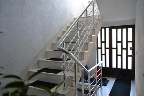 a white staircase with a metal railing in a building at Apartment in Prilep in Prilep
