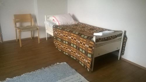 a small bed in a room with a chair at Suvannonrannan Majoitukset in Kauhajoki