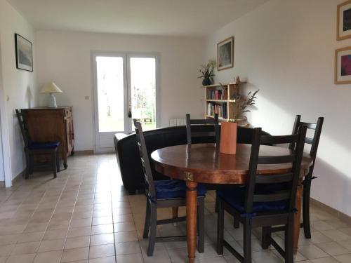 a dining room with a wooden table and chairs at Maison de vacances au calme in Angles