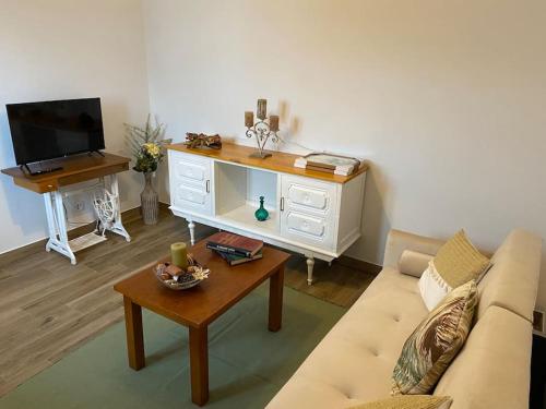 a living room with a couch and a tv at Casa da Bisa in Carreiras