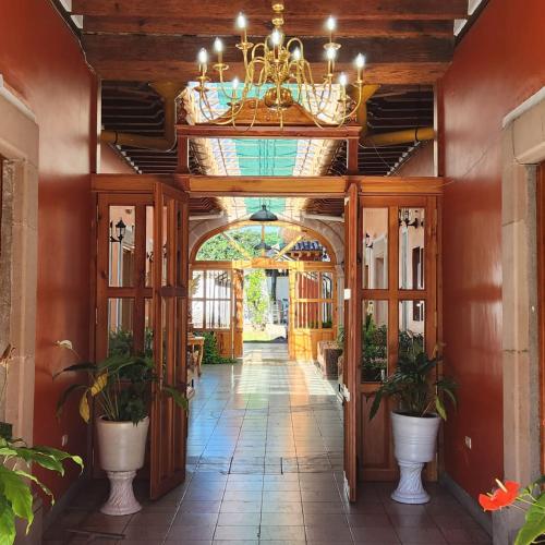 a hallway in a house with a chandelier at La Casa Baez in Pátzcuaro