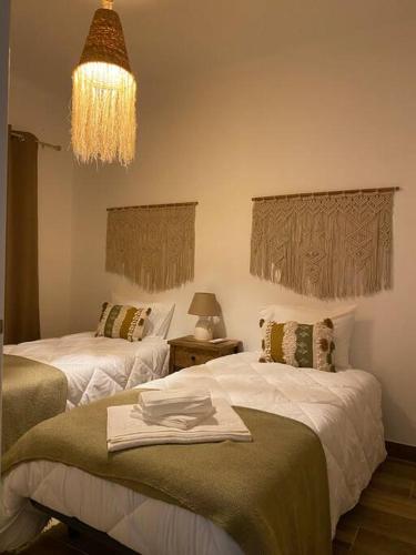 a hotel room with two beds and a chandelier at Casa da Bisa in Carreiras