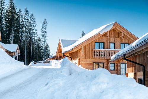 a log cabin in the snow with snow piled up at Poolchalet Dachsteinblick in Pruggern