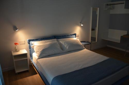 a bed with white sheets and pillows in a bedroom at La Cicada in Camerano