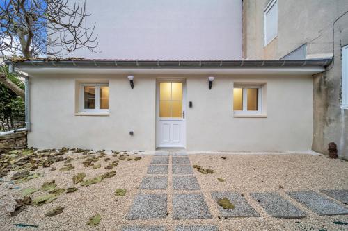 une maison blanche avec une porte blanche dans l'établissement Élégance & Calme : Centre/Gare/Cité Gastronomie, à Dijon