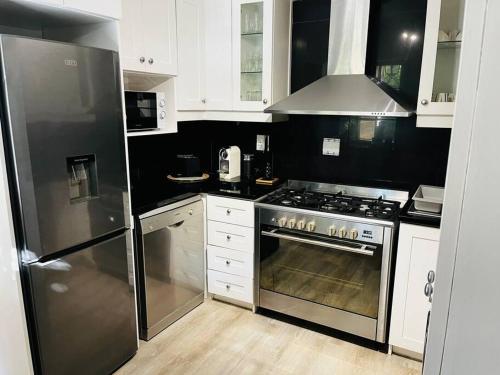 a kitchen with a stainless steel stove and refrigerator at The Olive Tree Cottage in Riebeek-Wes