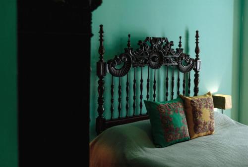 a bed with a wooden head board with pillows on it at Lisbon Art Stay Apartments Baixa in Lisbon