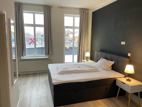 um quarto com uma cama grande e uma janela em Hotel & Gastro Adler GmbH em Itzehoe