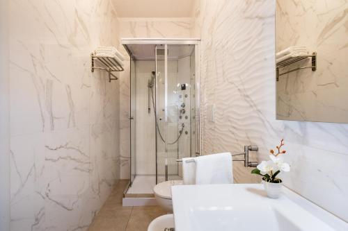 a white bathroom with a shower and a sink at Over The Top - Lu Sule in Copertino