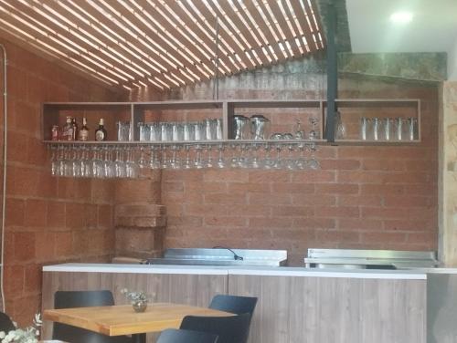 a restaurant with a counter with glasses on the wall at Hotel Loma Encantada, Guatapé - Piedra del Peñol in Guatapé