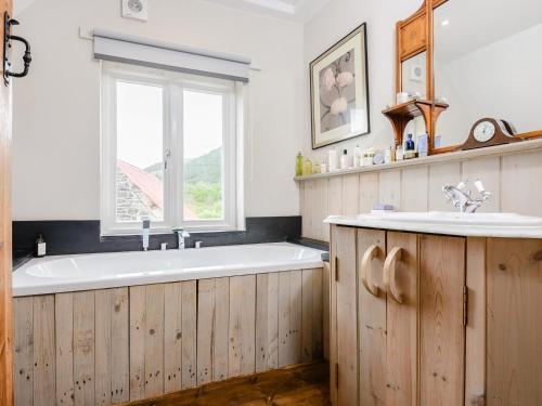 a bathroom with a bath tub and a window at 4 Bed in Llanidloes 51651 in Llandinam