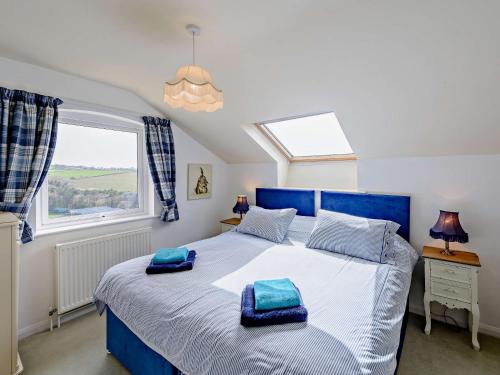 um quarto com uma cama grande e almofadas azuis em 5 Bed in Instow 54485 em Instow
