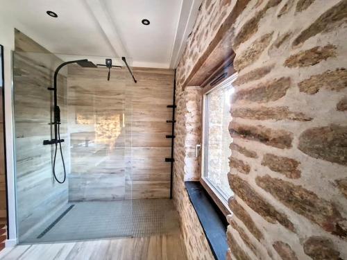 a bathroom with a shower with a stone wall at Studio Duplex Calme-Parking-Wifi in Comps-la-Grand-Ville