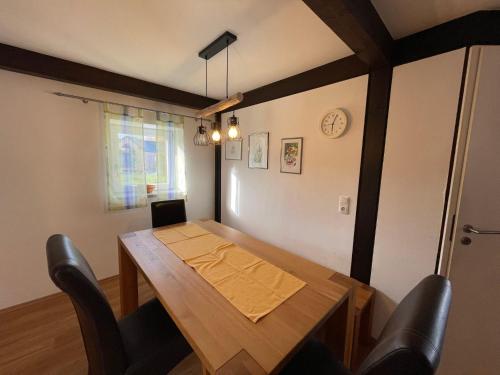 a dining room with a wooden table and black chairs at Holiday Home Jägerwiesen-8 by Interhome in Waldkirchen