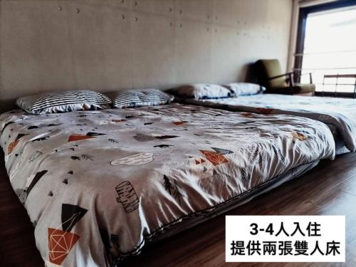 a bed with a comforter on it in a room at Taipei Jinguashi Cloud Mountain Homestay B&B in Jiufen