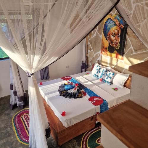 a bedroom with a bed with a painting of a woman at TIANDE Boutique Hotel in Pwani Mchangani