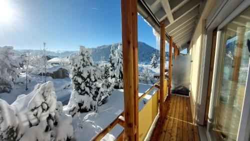 un balcón de una casa con árboles nevados en Ferienhaus Kirsch en Missen-Wilhams