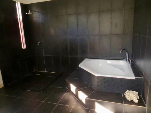 uma banheira na casa de banho com um chuveiro em Luxury Villa: Private Pool & Beach Retreat em Boracay