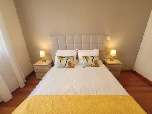 a bedroom with a large white bed with two lamps at Pilar Balconies in Funchal City in Funchal