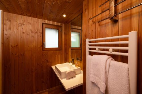 CublizeにあるCamping Le Lac des Sapinsの白い洗面台と木製の壁が備わるバスルーム