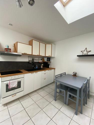 a kitchen with white cabinets and a table in it at Bienvenue au parc St Pierre in Amiens