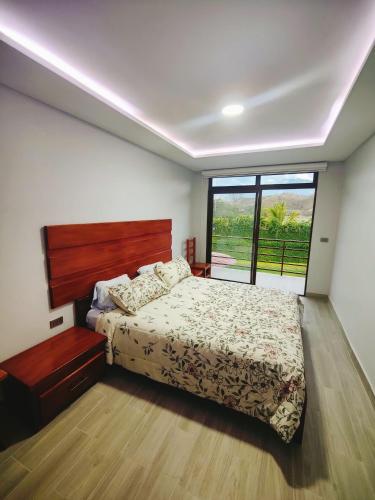een slaapkamer met een bed en een groot raam bij Quinta Esperanza - Habitación Matrimonial in Loja