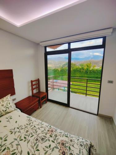 a bedroom with a bed and a large sliding glass door at Quinta Esperanza - Habitación Matrimonial in Loja