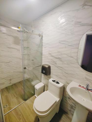 a bathroom with a toilet and a sink and a shower at Quinta Esperanza - Habitación Matrimonial in Loja