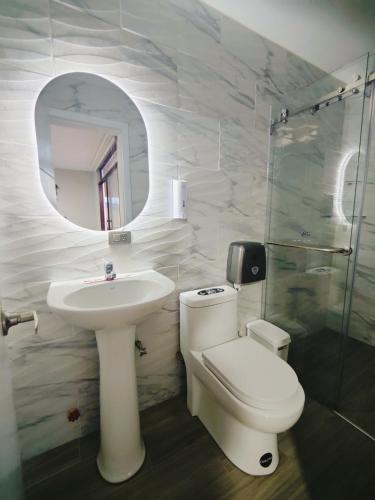 a bathroom with a toilet and a sink and a mirror at Quinta Esperanza - Habitación Matrimonial in Loja