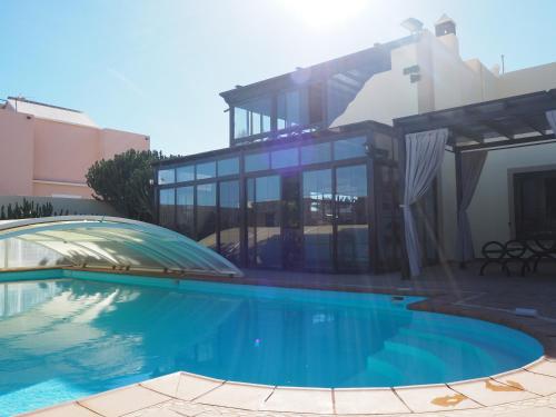una casa con piscina frente a una casa en Luxury Canarian villa with large pool and apartment in Costa Teguise en Teguise
