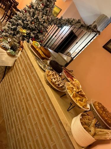 une table recouverte de assiettes de nourriture et d'un arbre de Noël dans l'établissement B&B Il Girasole - Suite & Luxury Private Spa, à Castel di Sangro
