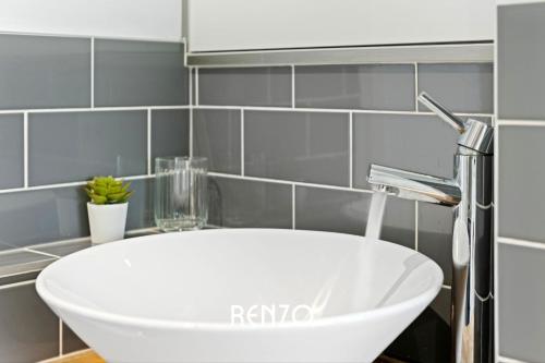 a white sink in a bathroom with a faucet at Vibrant 3-bed House in Nottingham by Renzo, Amazing Location, Sleeps 6! in Nottingham