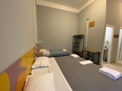 a bedroom with two beds and a mirror at Eureka Rooms in Rome