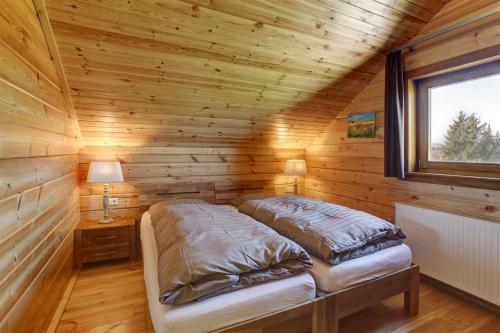 een slaapkamer met een bed in een houten hut bij Ecolodge 1 in Medebach