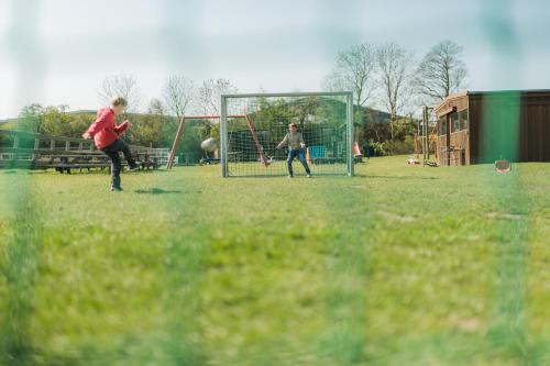 two people playing a game of soccer on a field at Büdlfarm - Der Familien-Erlebnishof in Strandnähe in Fehmarn