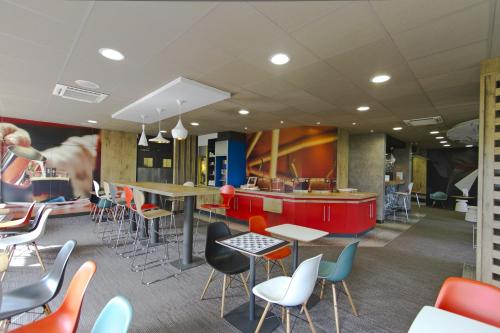 a restaurant with colorful chairs and tables and a counter at ibis Chambery in Chambéry