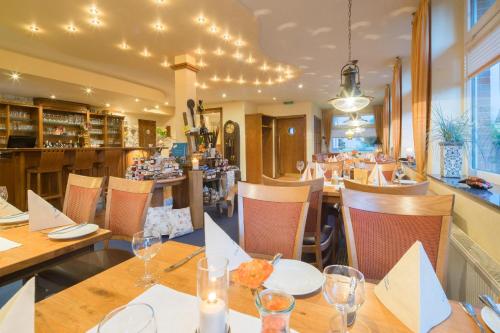 un restaurante con mesas y sillas de madera y un bar en Hotel Strandburg, en Baltrum